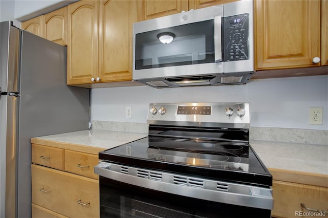 kitchen with light brown cabinetry and appliances with stainless steel finishes