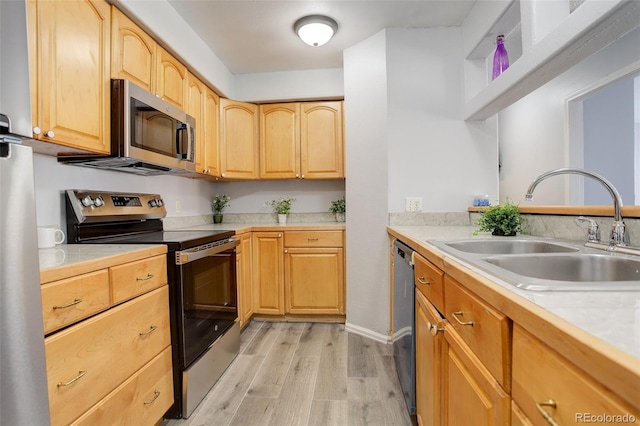 kitchen featuring stainless steel appliances, light hardwood / wood-style floors, light brown cabinets, and sink