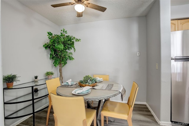 dining room with wood-type flooring, a textured ceiling, and ceiling fan