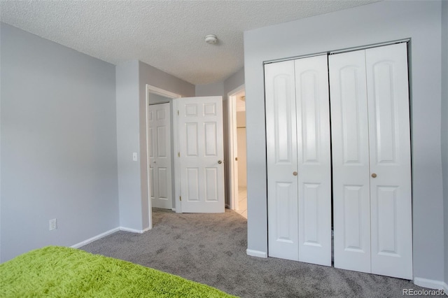 unfurnished bedroom with a closet, carpet floors, and a textured ceiling