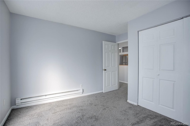 unfurnished bedroom with carpet flooring, a textured ceiling, a baseboard radiator, and a closet