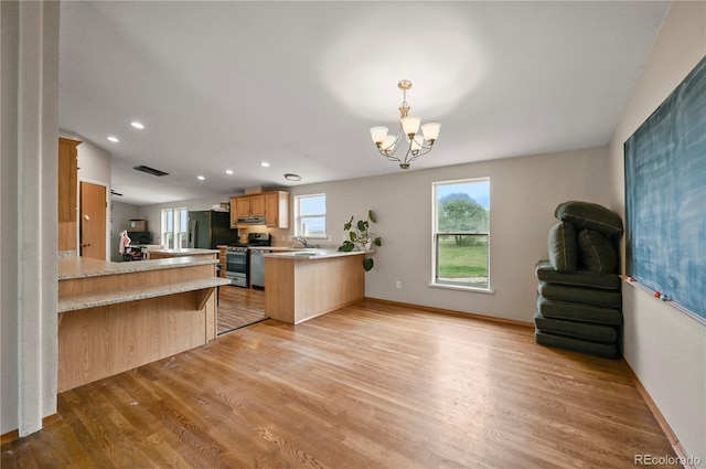 5520 Coyote Ln, Peyton, CO 80831 - kitchen featuring appliances with stainless steel finishes, a peninsula, light wood-type flooring, light countertops, and a chandelier