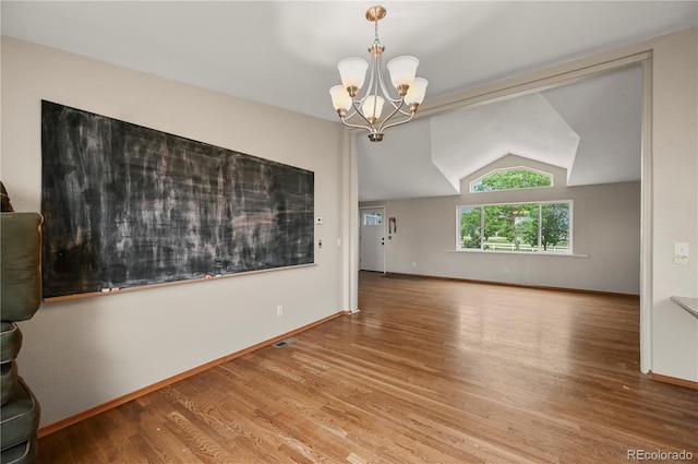 5520 Coyote Ln, Peyton, CO 80831 - empty room featuring lofted ceiling, wood finished floors, and a chandelier