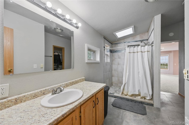 5520 Coyote Ln, Peyton, CO 80831 - full bath featuring a stall shower, vanity, vaulted ceiling, tile patterned floors, and a walk in closet