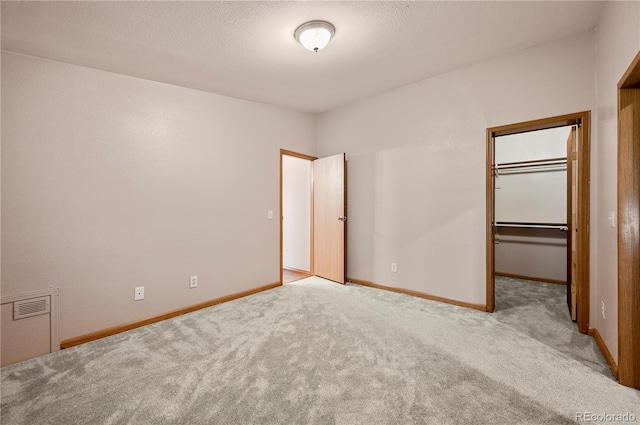 5520 Coyote Ln, Peyton, CO 80831 - unfurnished bedroom featuring carpet floors, a walk in closet, and a textured ceiling