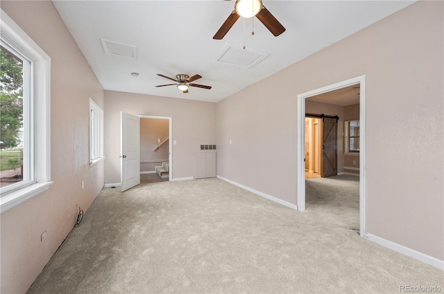 5520 Coyote Ln, Peyton, CO 80831 - carpeted empty room featuring attic access, a ceiling fan, and a barn door