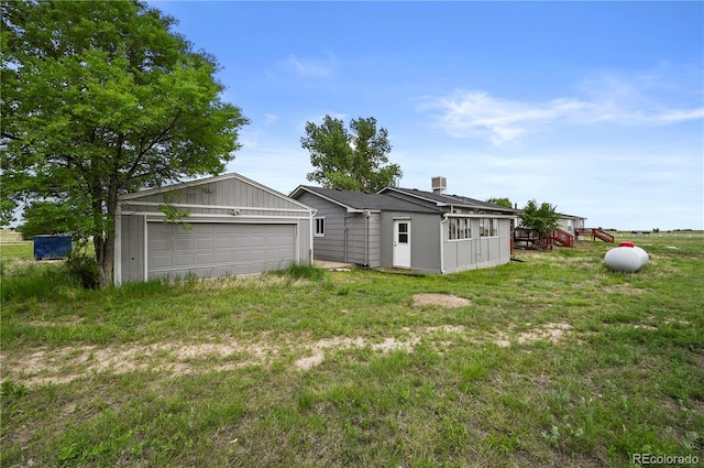 5520 Coyote Ln, Peyton, CO 80831 - rear view of house with a garage and a lawn