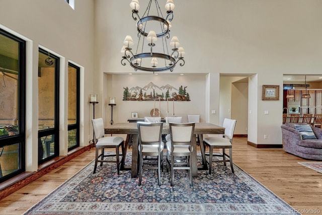 1250 Cottontail Trl, Woodland Park, CO 80863 - dining area with a chandelier, wood finished floors, a towering ceiling, and plenty of natural light