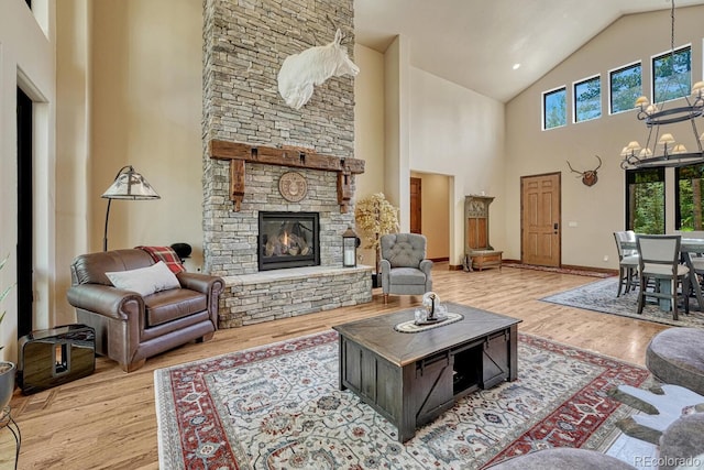 1250 Cottontail Trl, Woodland Park, CO 80863 - living room with high vaulted ceiling, a fireplace, wood finished floors, and a chandelier