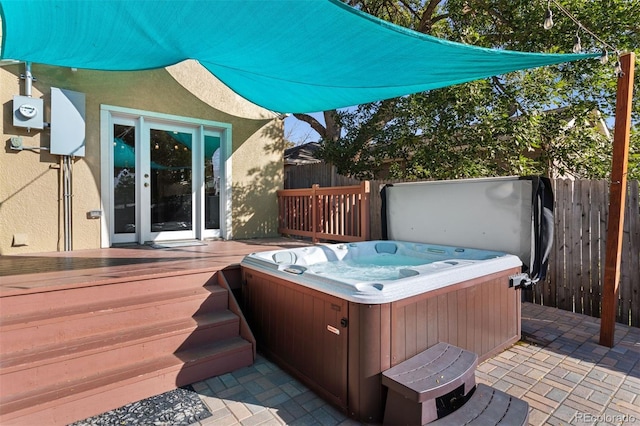 wooden deck featuring a hot tub and a patio