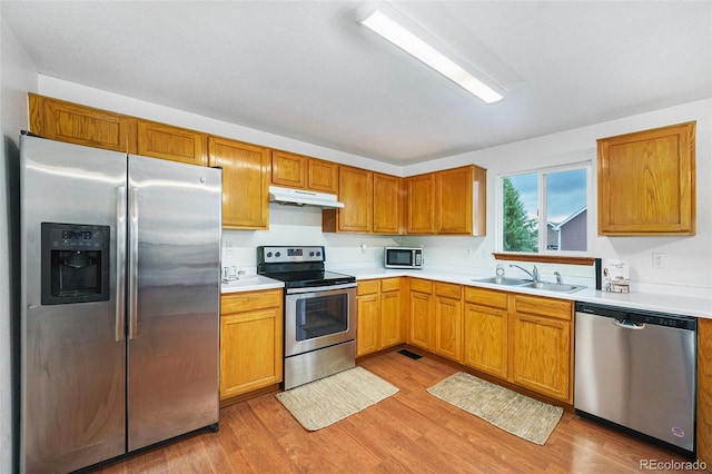 13504 Pecos St, Westminster, CO 80234 - kitchen with stainless steel appliances, under cabinet range hood, light wood-style floors, and light countertops