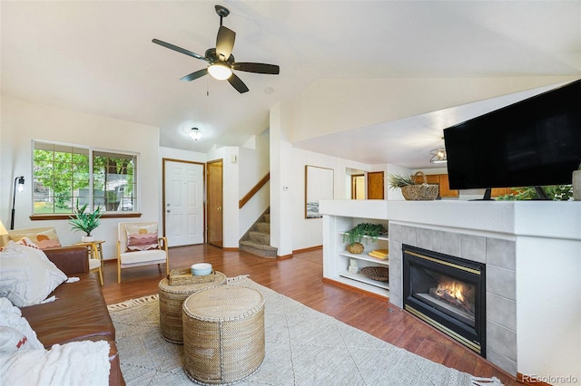 13504 Pecos St, Westminster, CO 80234 - living room featuring vaulted ceiling, a tiled fireplace, stairway, ceiling fan, and wood finished floors