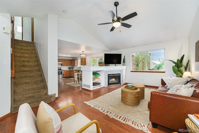 13504 Pecos St, Westminster, CO 80234 - living area featuring lofted ceiling, dark wood-style flooring, stairs, a ceiling fan, and a tile fireplace