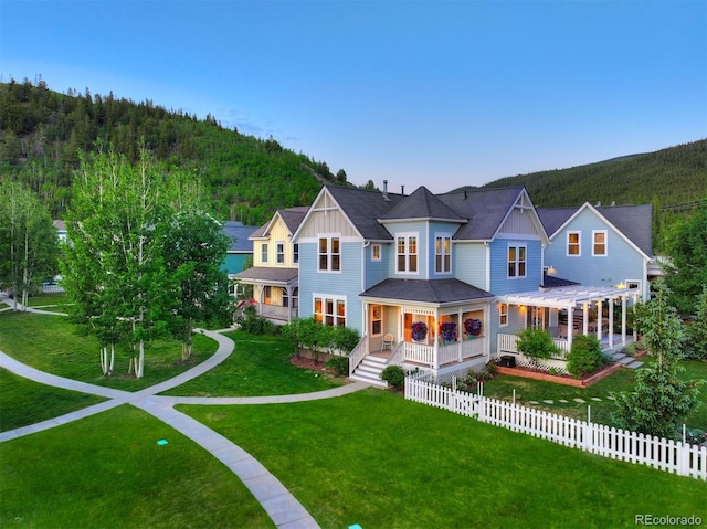 17 Meadow Lark Grn, Breckenridge, CO 80424 - view of front of house with board and batten siding, a pergola, a wooded view, and a porch
