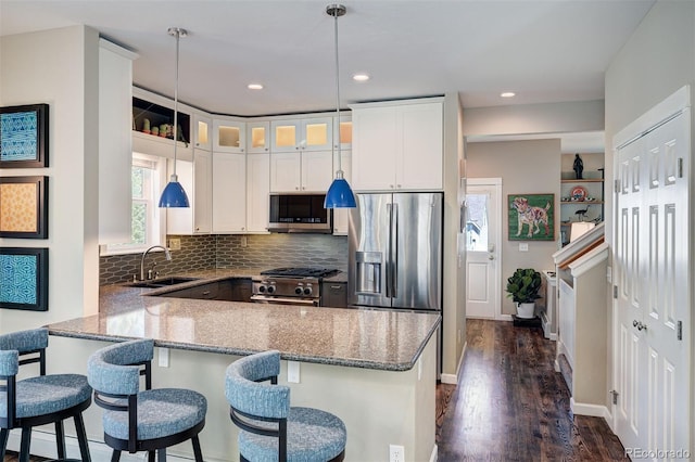 17 Meadow Lark Grn, Breckenridge, CO 80424 - kitchen with stainless steel appliances, a peninsula, light stone counters, white cabinetry, and dark wood-type flooring