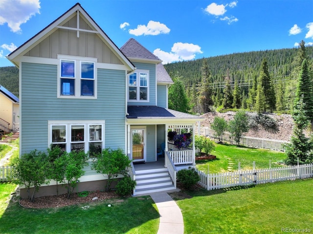 17 Meadow Lark Grn, Breckenridge, CO 80424 - view of front of property featuring a wooded view, covered porch, board and batten siding, and roof with shingles