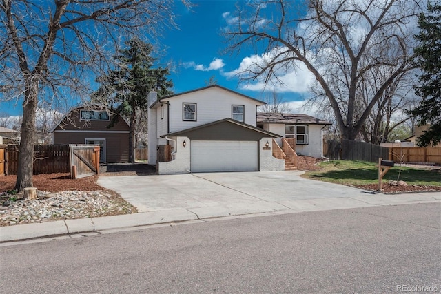 8170 S Marshall Ct, Littleton, CO 80128 - view of front facade with fence, an attached garage, and concrete driveway