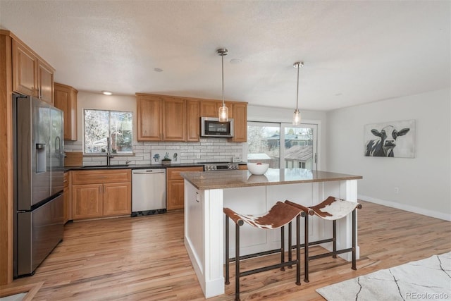 8170 S Marshall Ct, Littleton, CO 80128 - kitchen featuring plenty of natural light, a sink, light wood finished floors, appliances with stainless steel finishes, and backsplash