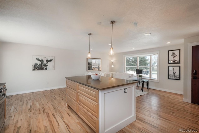 8170 S Marshall Ct, Littleton, CO 80128 - kitchen with a kitchen island, dark countertops, hanging light fixtures, baseboards, and light wood-style floors