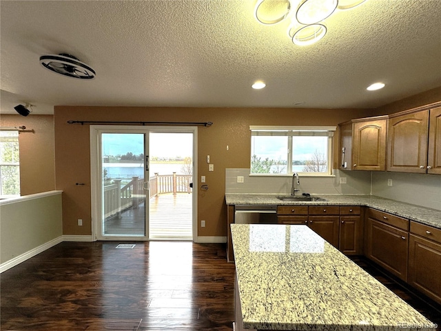 kitchen with a sink, dark wood finished floors, baseboards, a textured ceiling, and recessed lighting