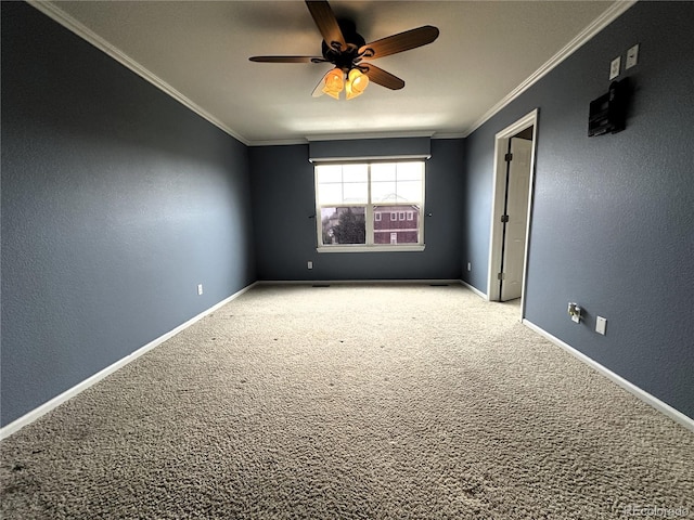 carpeted empty room featuring ceiling fan, ornamental molding, and baseboards