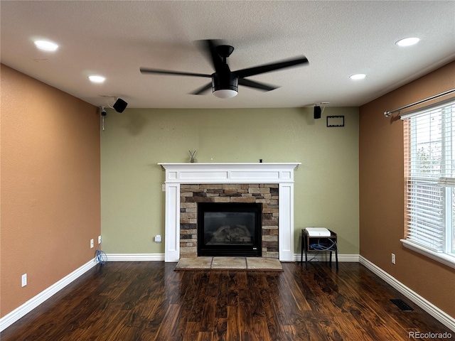 living room with a stone fireplace, wood finished floors, a ceiling fan, recessed lighting, and baseboards