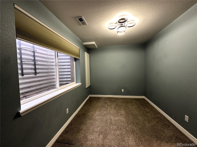 unfurnished room with carpet, baseboards, and a textured ceiling