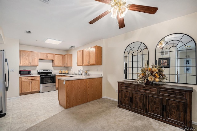 2900 Purcell St Unit 6, Brighton, CO 80601 - kitchen with appliances with stainless steel finishes, a peninsula, a ceiling fan, and light countertops