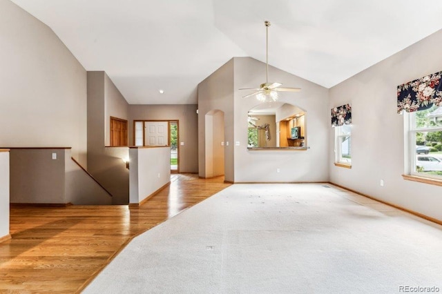 interior space with ceiling fan, baseboards, wood finished floors, and vaulted ceiling