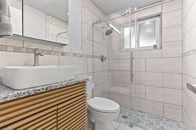 8333 Depew Way, Arvada, CO 80003 - bathroom with tile walls, a stall shower, vanity, toilet, and tile patterned flooring