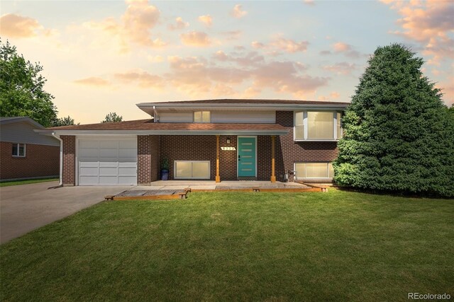 8333 Depew Way, Arvada, CO 80003 - view of front of house with driveway, brick siding, an attached garage, and a front yard