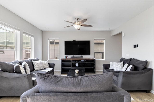 living area with light wood finished floors, ceiling fan, and baseboards