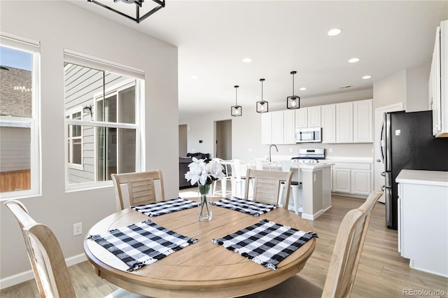 dining room featuring recessed lighting, baseboards, and light wood finished floors