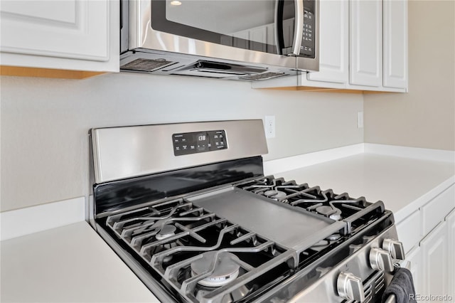 interior details with white cabinetry, light countertops, and stainless steel appliances