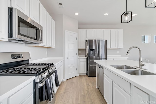 kitchen featuring appliances with stainless steel finishes, light countertops, and a sink