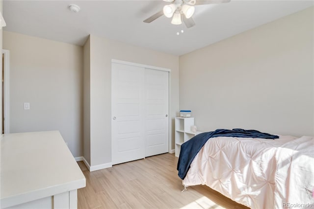 bedroom featuring light wood finished floors, baseboards, a closet, and a ceiling fan