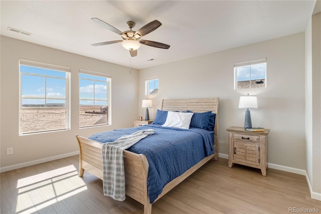 bedroom with a ceiling fan, light wood-style flooring, baseboards, and visible vents