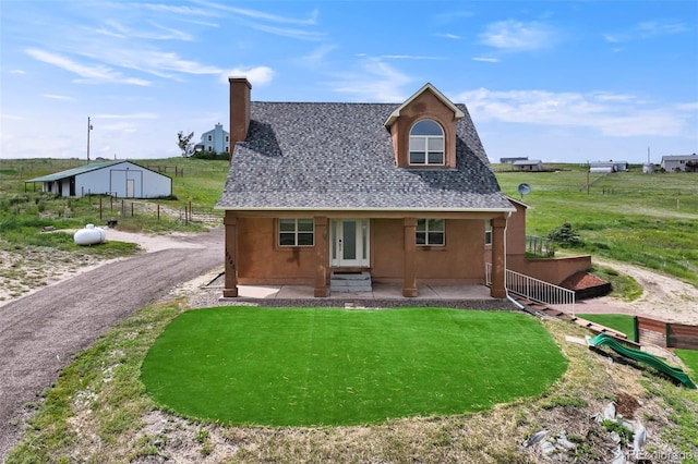 15580 Rigge Ct, Elbert, CO 80106 - rear view of house featuring roof with shingles, a chimney, stucco siding, an outdoor structure, and a patio area