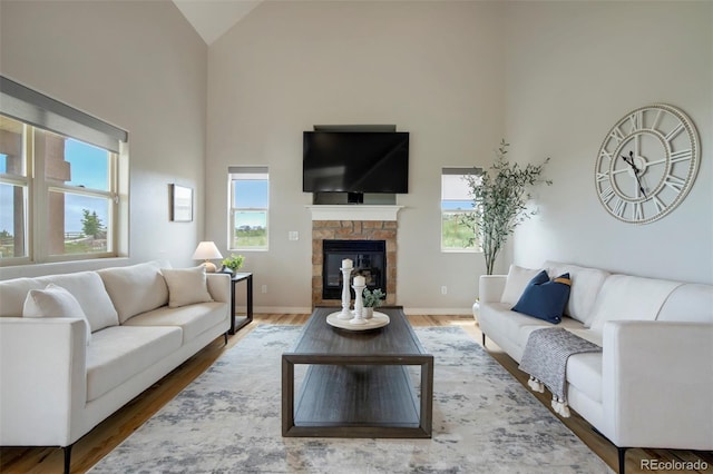 15580 Rigge Ct, Elbert, CO 80106 - living area with high vaulted ceiling, a fireplace, wood finished floors, and baseboards