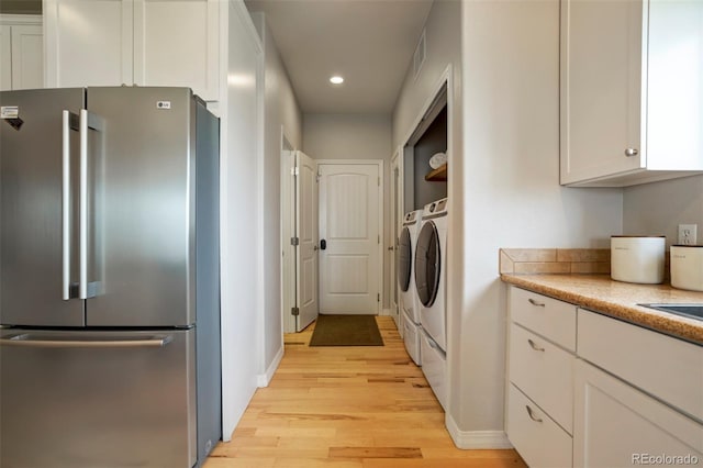 15580 Rigge Ct, Elbert, CO 80106 - laundry area with light wood-style flooring, washing machine and clothes dryer, recessed lighting, and baseboards