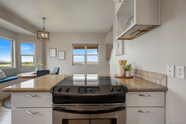 15580 Rigge Ct, Elbert, CO 80106 - kitchen with stainless steel electric range oven, white cabinets, light stone countertops, and pendant lighting
