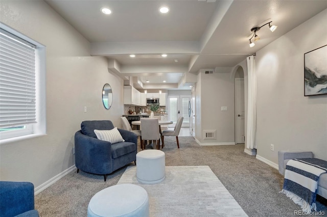 15580 Rigge Ct, Elbert, CO 80106 - living room with light colored carpet, healthy amount of natural light, arched walkways, baseboards, and recessed lighting