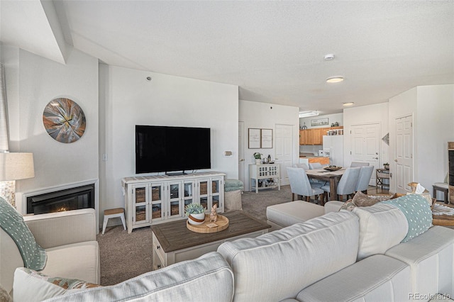 carpeted living room featuring a glass covered fireplace