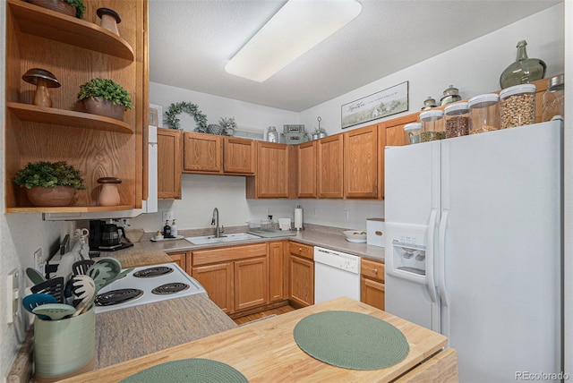 kitchen with white appliances, light countertops, a sink, and open shelves