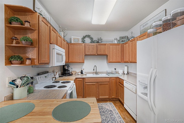 kitchen featuring a sink, open shelves, white appliances, and light countertops