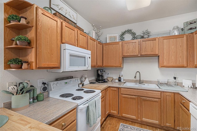 kitchen with white appliances, open shelves, a sink, and light countertops