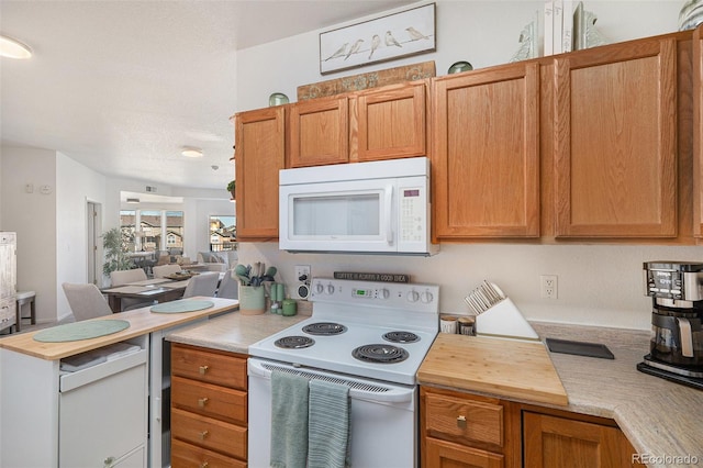 kitchen featuring butcher block countertops, white appliances, and open floor plan