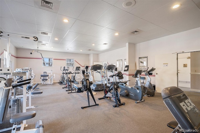 workout area with a drop ceiling, visible vents, and recessed lighting