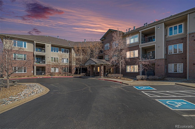 property at dusk featuring uncovered parking