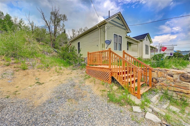 exterior space featuring driveway and a wooden deck